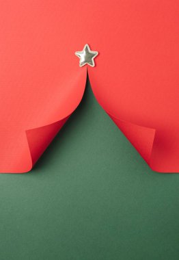 Noel ağacı şekilli, yeşil ve kırmızı arka planlı kağıt kesimi. Mutlu Noeller. Minimum düzlük.