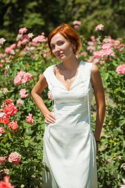 Schöne Frau im Rosengarten — Stockfoto