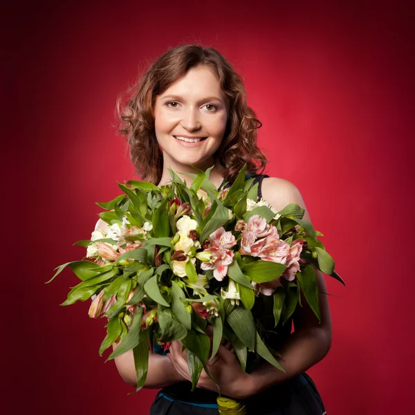 Portrait of pretty brunette holding bouquet of flowers — Stock Photo, Image