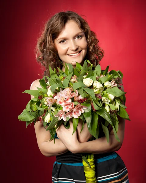 Portrait of pretty brunette holding bouquet of flowers — Stock Photo, Image