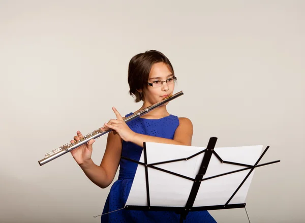 Menina tocando sua flauta em um vestido azul fantasia — Fotografia de Stock