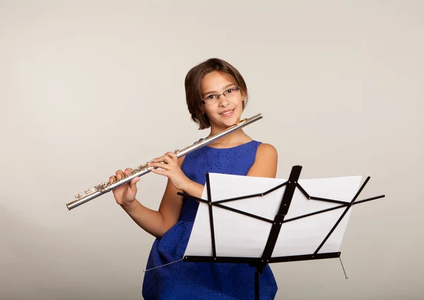 Menina tocando sua flauta em um vestido azul fantasia — Fotografia de Stock