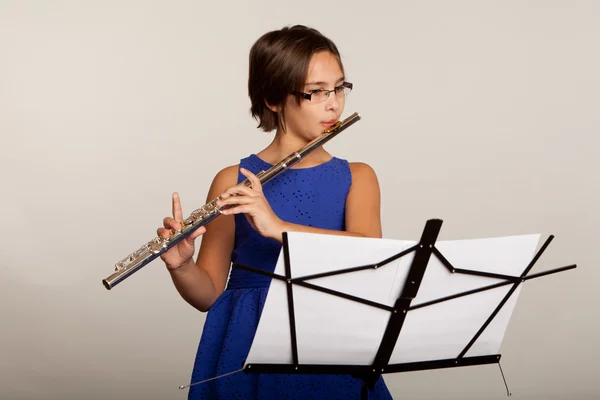 Menina tocando sua flauta em um vestido azul fantasia — Fotografia de Stock