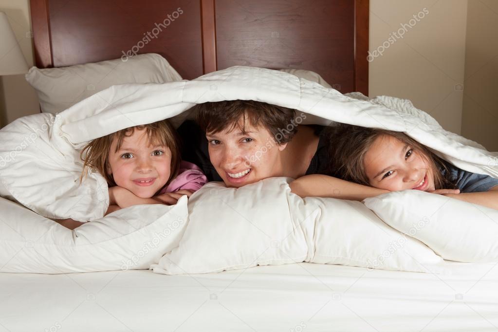 Mother and two daughters in bed