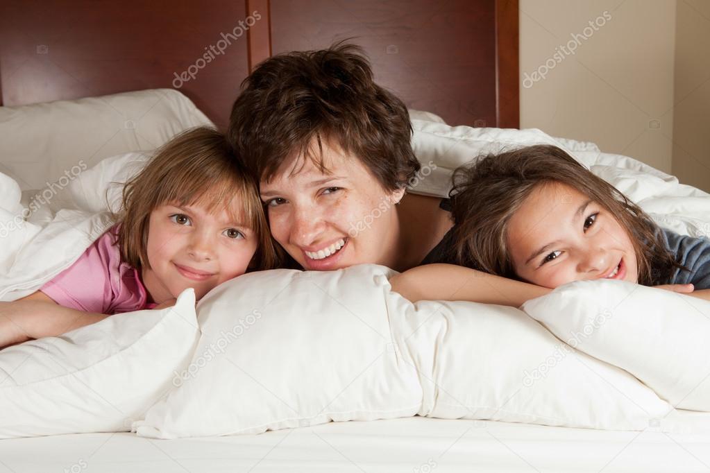 Mother and two daughters in bed