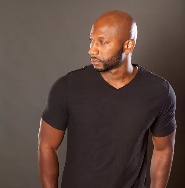 잘 생긴 운동 흑인 남자 캐주얼 포즈 에 a 검정 셔츠 스톡 이미지