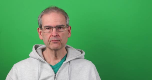 Vtipný klip muže na zelené obrazovce, jak dělá obličej a drží výzdobu srdce — Stock video