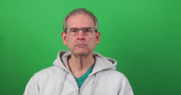 Αστεία κλιπ ενός άνδρα στην πράσινη οθόνη κάνει ένα πρόσωπο και κρατώντας ψηλά μια διακόσμηση καρδιά — Αρχείο Βίντεο