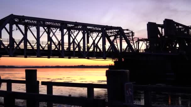 冬天的日落时分，换乘火车经过一座钢桥 — 图库视频影像