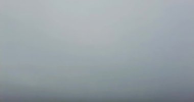 Sakin dalgalar sisli bir kış gününde kıyıya vurur.