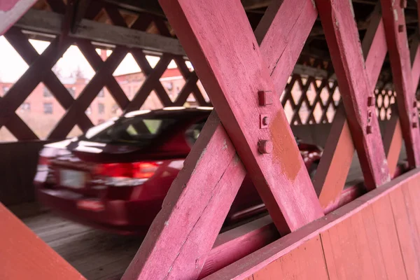 Rode auto over een overdekte brug Rechtenvrije Stockfoto's