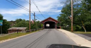 New England 'da üstü kapalı bir köprüden geçiyorum. New Hampshire 'da güneşli bir günde 4K' lık yüksek kaliteli çekim.