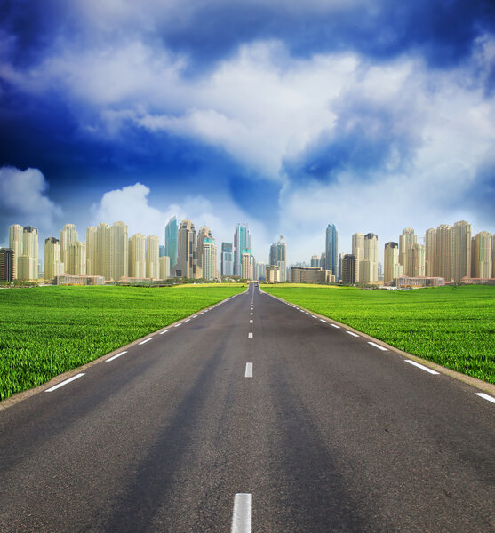 Green field and Dubai Town City on Horizont