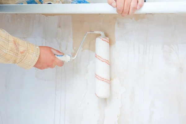 Mano en pared de pintura de rodillos — Foto de Stock