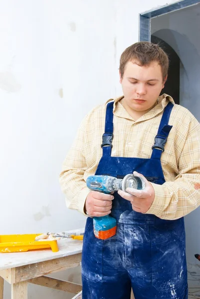 Junge Arbeiter halten Bohrer in der Hand — Stockfoto