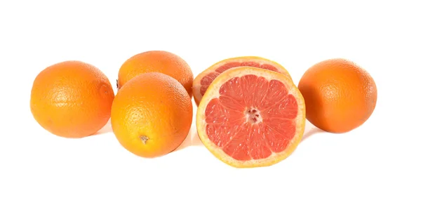 De hele sinaasappelen en de gesneden grapefruit — Stockfoto