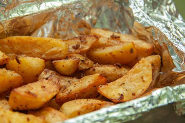 Folyoda fırında patates. Yemek servisi. Fırında pişmiş patatesin derisi.