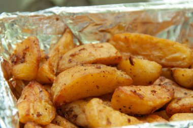 Folyoda fırında patates. Yemek servisi. Fırında pişmiş patatesin derisi..