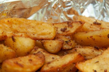 Folyoda fırında patates. Yemek servisi. Fırında pişmiş patatesin derisi.