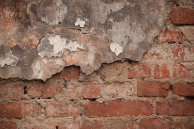 Eski püskü bir duvarın dokusu. Alçıdaki eski tuğlaların ve çatlakların geçmişi. Sarı ve kahverengi tonlar