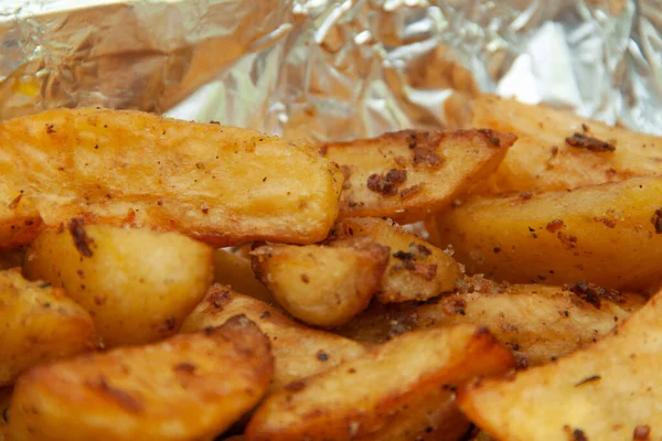 Folyoda fırında patates. Yemek servisi. Fırında pişmiş patatesin derisi.