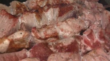 Şiş bir şişte döndürülmüş. Altın şişler pişti. Mutfak geçmişi. Lezzetli bir kızarmış et. Yakın plan.