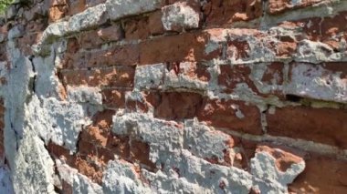 Eski kırmızı tuğla duvar yıpranmış. Güneşli bir gün. Tasarım ve sanat
