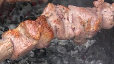 Şiş bir şişte döndürülmüş. Altın şişler pişti. Mutfak geçmişi. Lezzetli bir kızarmış et. Yakın plan.