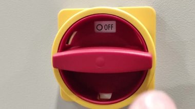 El kırmızı düğmeyi açıyor. El kırmızı düğmeyi çevirir. Elektrik düğmesi