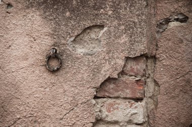 Eski püskü bir duvarın dokusu. Alçıdaki eski tuğlaların ve çatlakların geçmişi. Sarı ve kahverengi tonlar