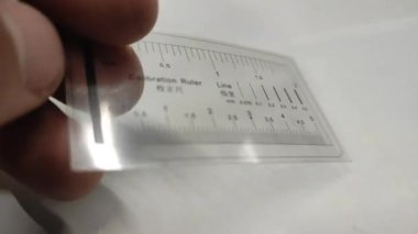 Kalibrasyon cetveli. Metal cetvelin doğruluğu şeffaf bir şablon ile kontrol edilir. Metroloji