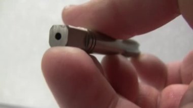 İplikleri kesmek için iplikler. Eldeki alet. Bir başlık aracının sunumu.