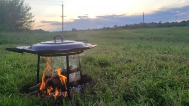Gün batımında kızartma tavası yanıyor. Doğada yemek pişirmek. Yüksek kalite 4k görüntü