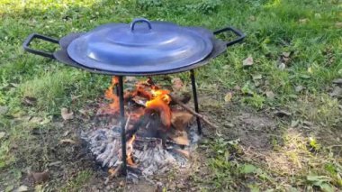 Gün batımında kızartma tavası yanıyor. Doğada yemek pişirmek. Yüksek kalite 4k görüntü