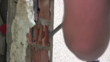 Bir delgiyle duvarı sökmek. Onarım ve bitirme. Bir kaya matkabı deliği açar. Yüksek kaliteli FullHD görüntüler