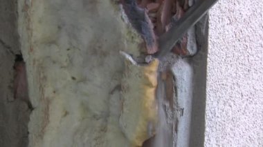 Bir delgiyle duvarı sökmek. Onarım ve bitirme. Bir kaya matkabı deliği açar. Yüksek kaliteli FullHD görüntüler
