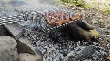 Sausages and meat are baked on the fire. meat food in a grid on coals. Food in nature. High quality FullHD footage
