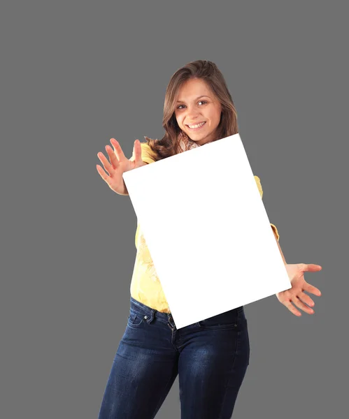 Retrato de una joven feliz sosteniendo un cartel en blanco sobre g — Foto de Stock