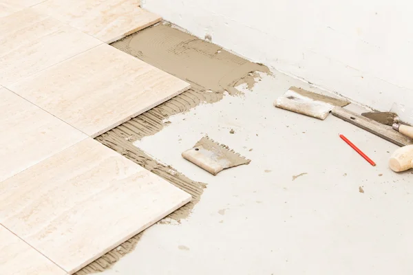 Workman's tools on a floor that is being tiled — Stock Photo, Image