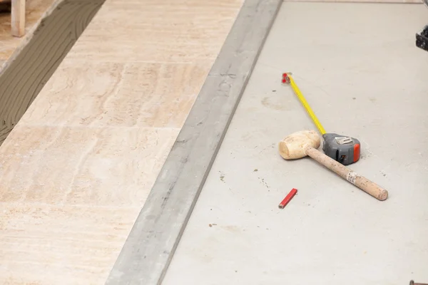 Workman's tools on a floor that is being tiled — Stock Photo, Image