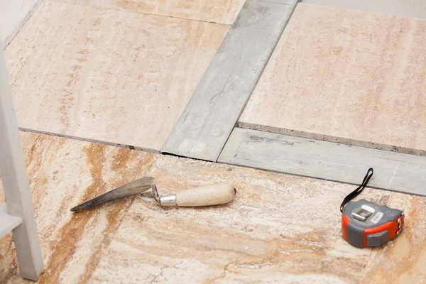 Handwerkerwerkzeuge auf einem Fußboden, der gefliest wird — Stockfoto