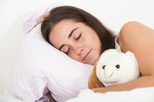 Mulher dormindo com um urso de pelúcia — Fotografia de Stock