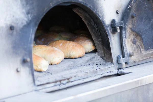 Traditionella baka bröd i en vedugn — Stockfoto