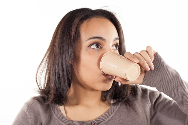 Женщина пьет из пластиковой чашки — стоковое фото