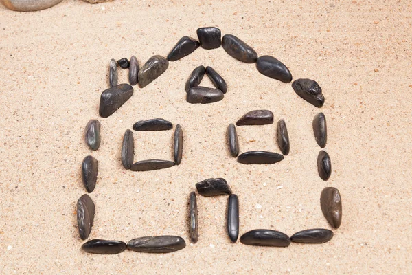 Haus mit Kieselsteinen auf dem Sand eines Strandes — Stockfoto