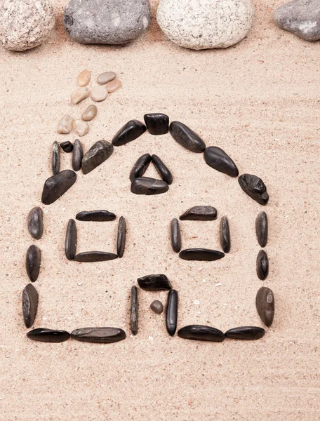 Home designed with pebbles on the sand of a beach — Stock Photo, Image