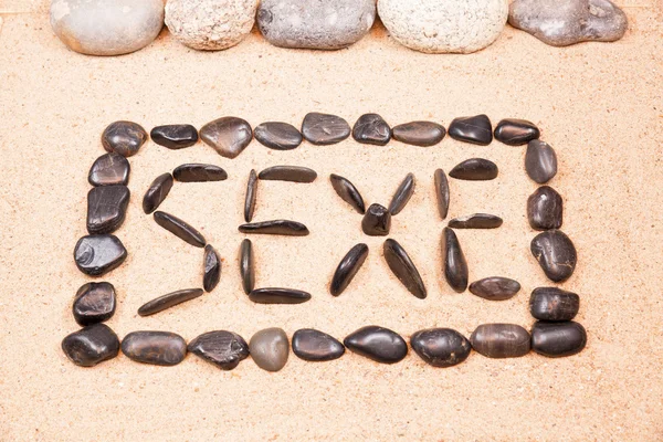 Word sexe written with pebbles on the sand — Stock Photo, Image