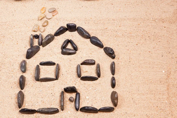 Haus mit Kieselsteinen im Sand — Stockfoto