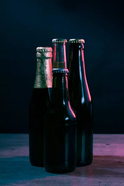 Siluetas Cuatro Botellas Cerveza Sobre Fondo Negro Con Luces Azules —  Fotos de Stock