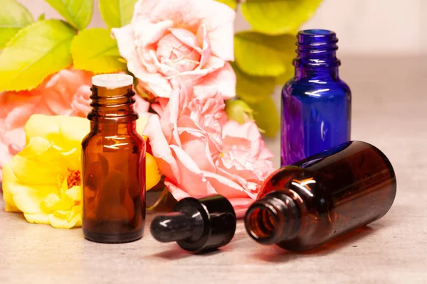 rose flowers and bottles of essential oils for aromatherapy